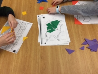 Students explore tangrams with handheld manipulatives